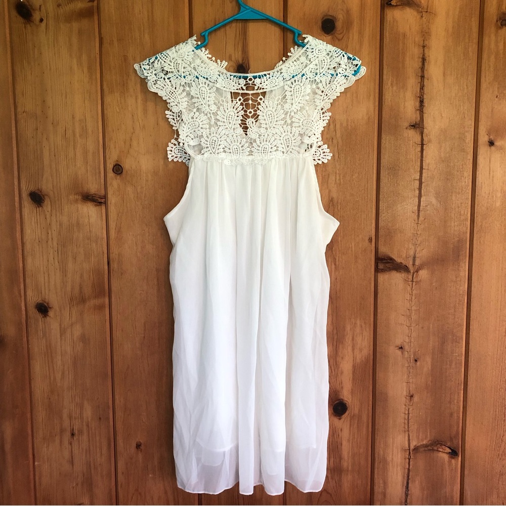 White, sleeveless mini dress with hollow lace.  Lined.